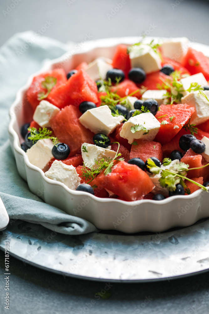 Summer salad with watermelon, feta cheese and mint on a gray background. Vegan, European food. Summer salad with watermelon, feta cheese and mint on a gray background. Vegan, European food.
