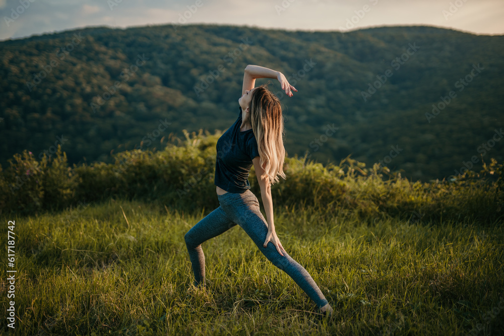 In a breathtaking landscape of rolling hills, a woman stands tall in mountain pose, connecting with the earth beneath her. In a breathtaking landscape of rolling hills, a woman stands tall in mountain pose, connecting with the earth beneath her.