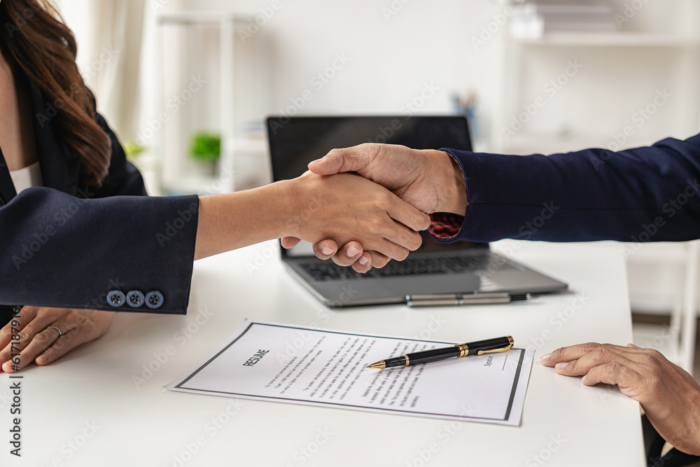 Job interview. Two businessmen shake hands to submit resume documents. HR manager shakes hands congratulating job candidates for successful job application close up pictures Job interview. Two businessmen shake hands to submit resume documents. HR manager shakes hands congratulating job candidates for successful job application close up pictures