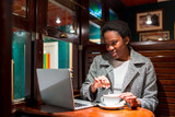 Business woman of African ethnicity in a coffee shop, moment of rest finance woman having a coffee
