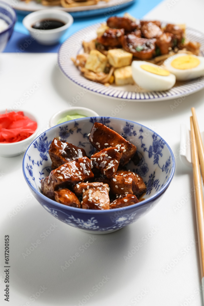 Bowl of tasty chicken meat in teriyaki sauce on light background Bowl of tasty chicken meat in teriyaki sauce on light background