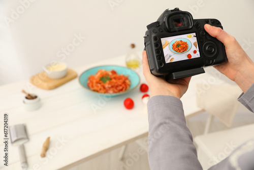 Fototapeta Naklejka Na Ścianę i Meble -  Food stylist taking photo of delicious spaghetti in studio, closeup. Space for text