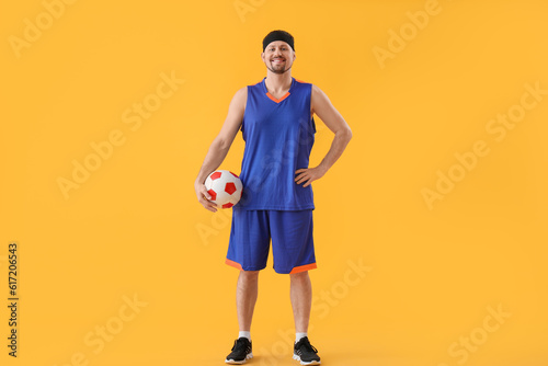 Soccer player with ball on yellow background