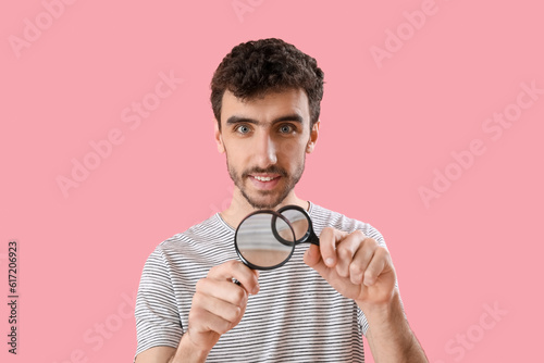 Young man with magnifiers o...