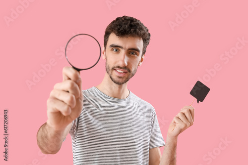 Young man with magnifier an...