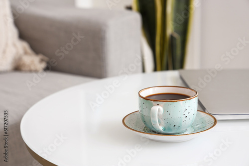 Fototapeta Naklejka Na Ścianę i Meble -  Cup of delicious coffee and modern laptop on table, closeup