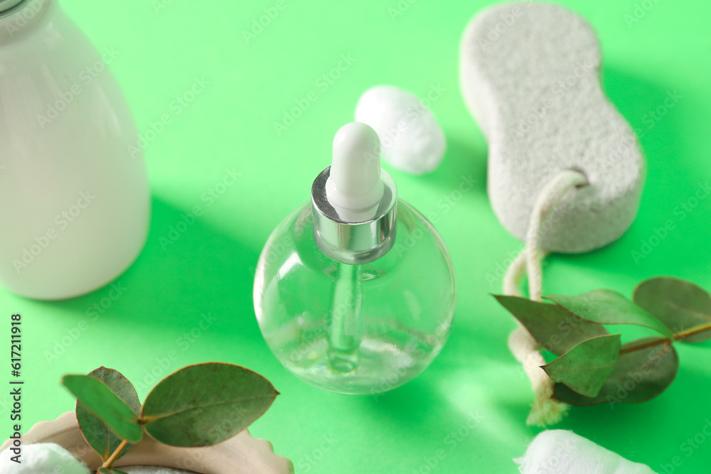 Bottles of cosmetic products and brush on green background, closeup Bottles of cosmetic products and brush on green background, closeup