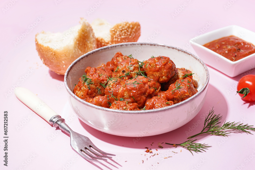 Bowl of tasty meat balls with sauce on pink background Bowl of tasty meat balls with sauce on pink background