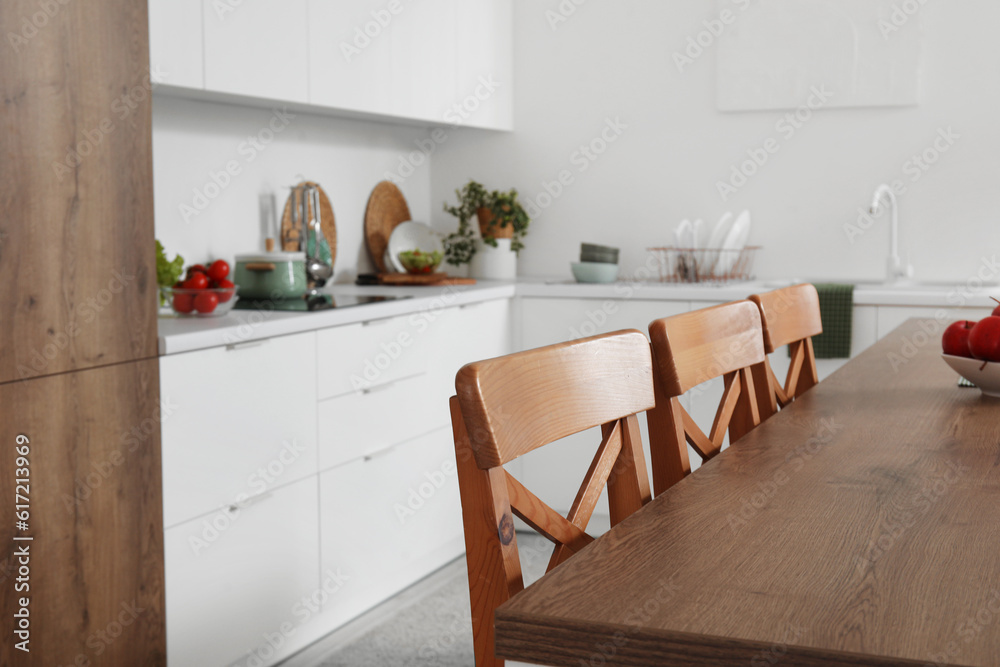 Wooden island table in interior of modern kitchen