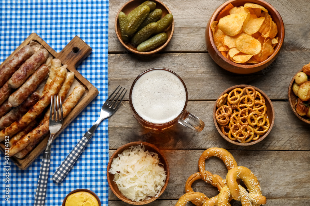 Mug of cold beer and different snacks on wooden background. Oktoberfest celebration Mug of cold beer and different snacks on wooden background. Oktoberfest celebration