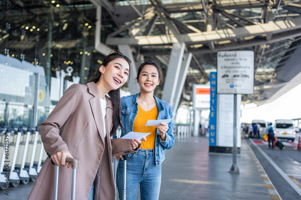 Asian two women passenger waiting a bus after leaving from the airport. Asian two women passenger waiting a bus after leaving from the airport.