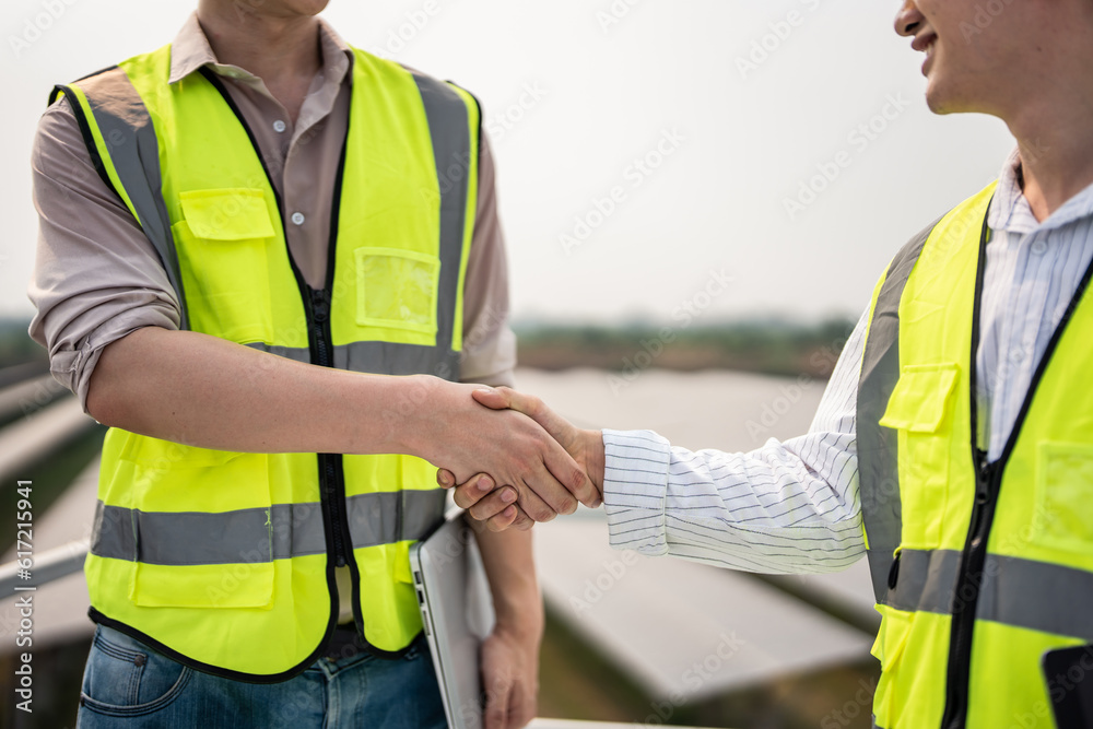 Professional engineer making handshake after work in modern solar farm. Professional engineer making handshake after work in modern solar farm.