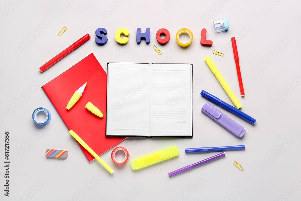 Notebooks with different stationery and word SCHOOL on white background Notebooks with different stationery and word SCHOOL on white background