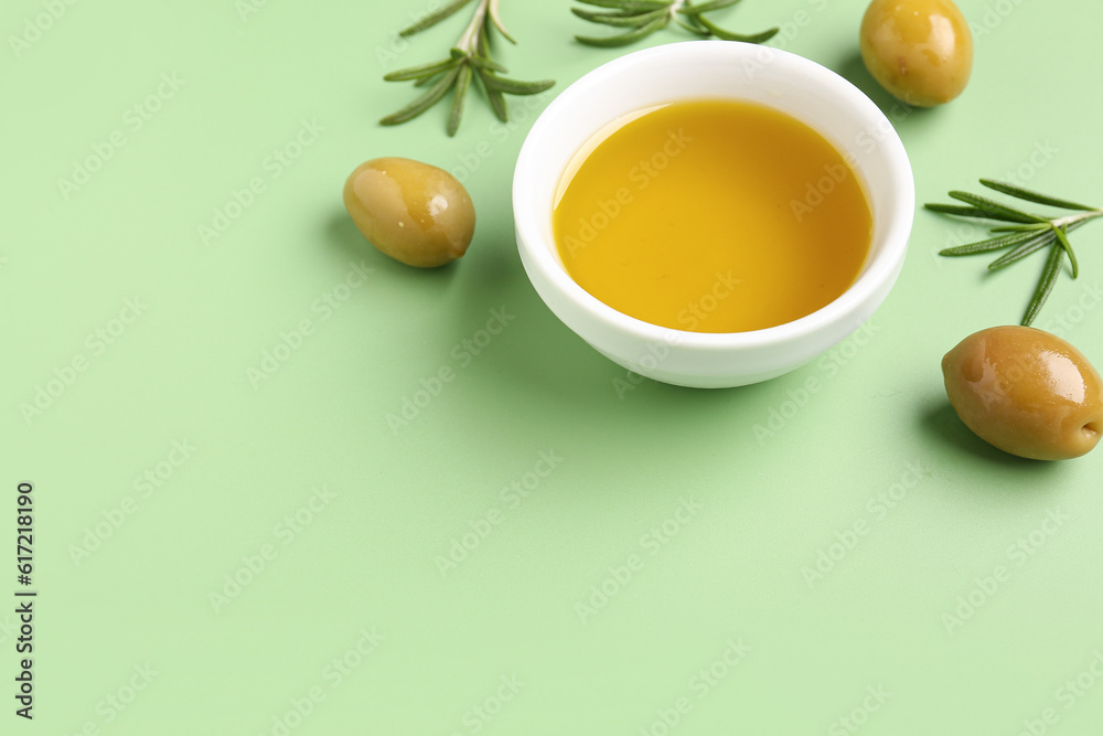 Bowl with fresh olive oil on green background Bowl with fresh olive oil on green background