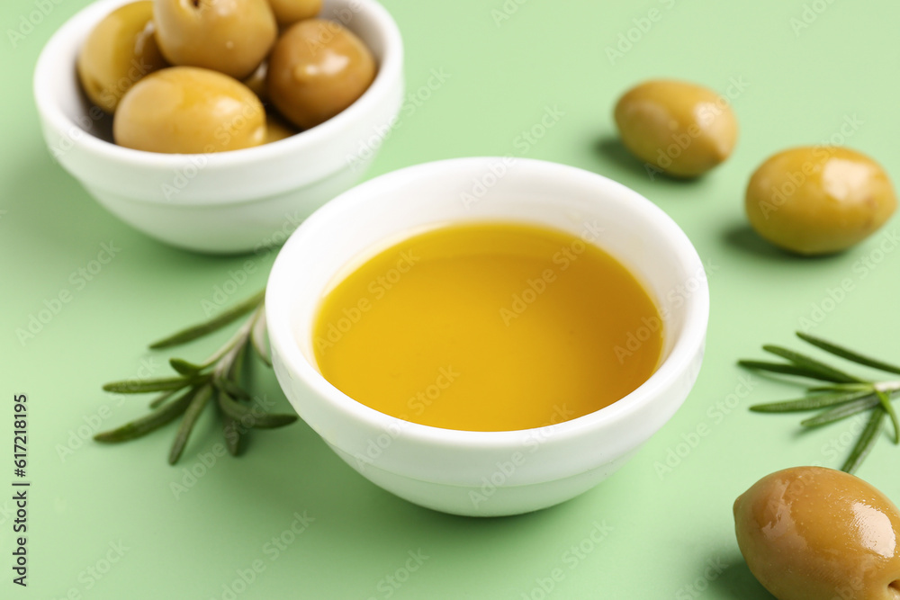 Bowl with fresh olive oil on green background Bowl with fresh olive oil on green background