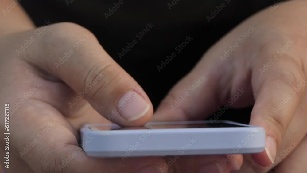 Finger of woman touching scroll page app on mobile phone. Browsing movie video in the internet library to watch film online. Finger of woman touching scroll page app on mobile phone. Browsing movie video in the internet library to watch film online.