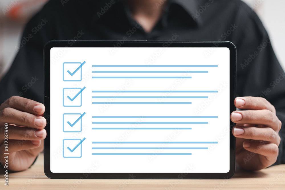 Checklist concept, businessman taking online checklist survey on tablet, filling out digital form checklist Checklist concept, businessman taking online checklist survey on tablet, filling out digital form checklist