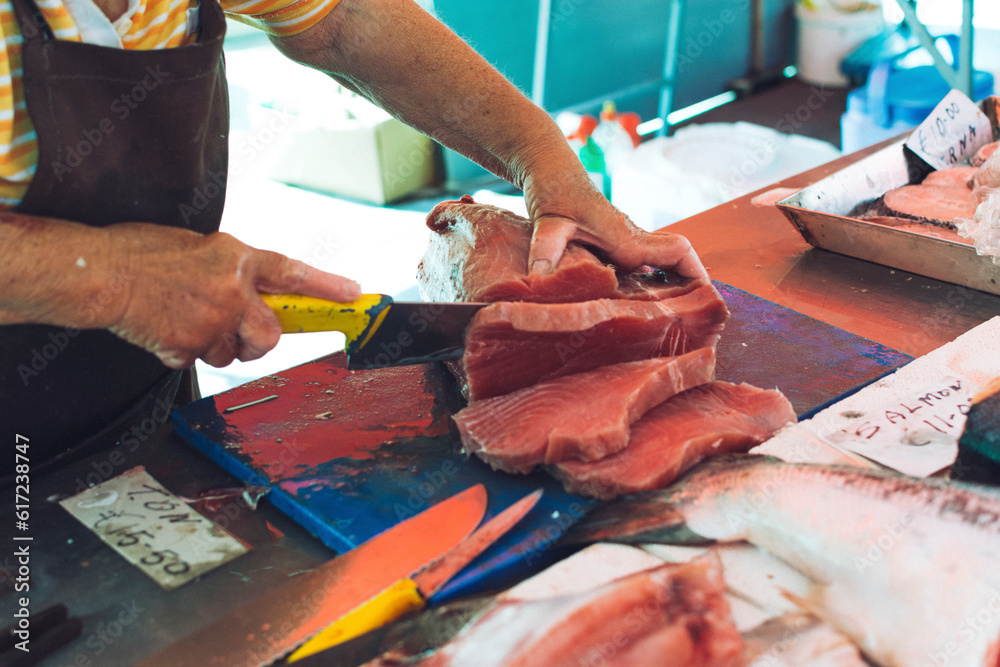Seller slicing a fish fillet