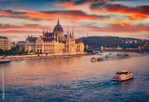 Old pleasure boats on Dunabe river with Parliament house on background. Stunning summer cityscape of Budapest. Amazing sunset in Hungary, Europe. Traveling concept background.