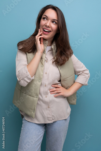 surprised brunette young lady in casual outfit on studio background