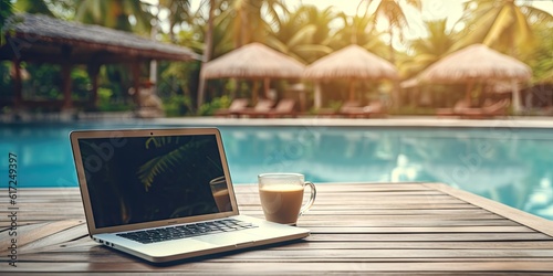 Work by the poolside. With laptop on wooden table. Technology and business for work where notebook opens up view to relax holiday. Lifestyle, travel, and digital freelancing by cup of coffee © Bussakon