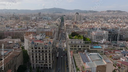 Forwards fly above Via Laietana street surrounded by rows of multistorey historic houses. Barcelona, Spain photo