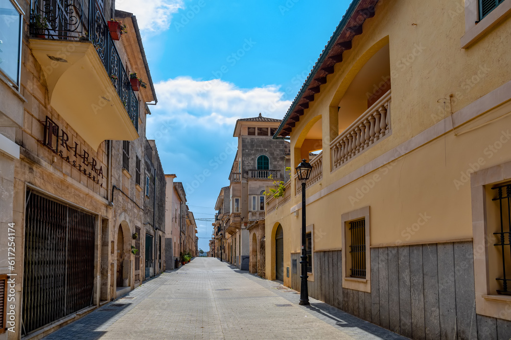 An idyllic scene of small village Petra old town, an empty narrow street lined with old facades, preserving the timeless charm of this Mediterranean gem. Balearic Islands Spain.