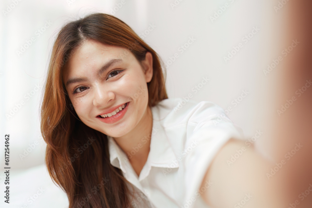 Happy smiling asian woman stretching on bed in the morning Happy smiling asian woman stretching on bed in the morning