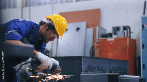 Worker man using grinding machine and cutting steel have spark from the grinding wheel at production factory industrial. Expert Man working hard in steel manufacturing plant. Factory  industry concept