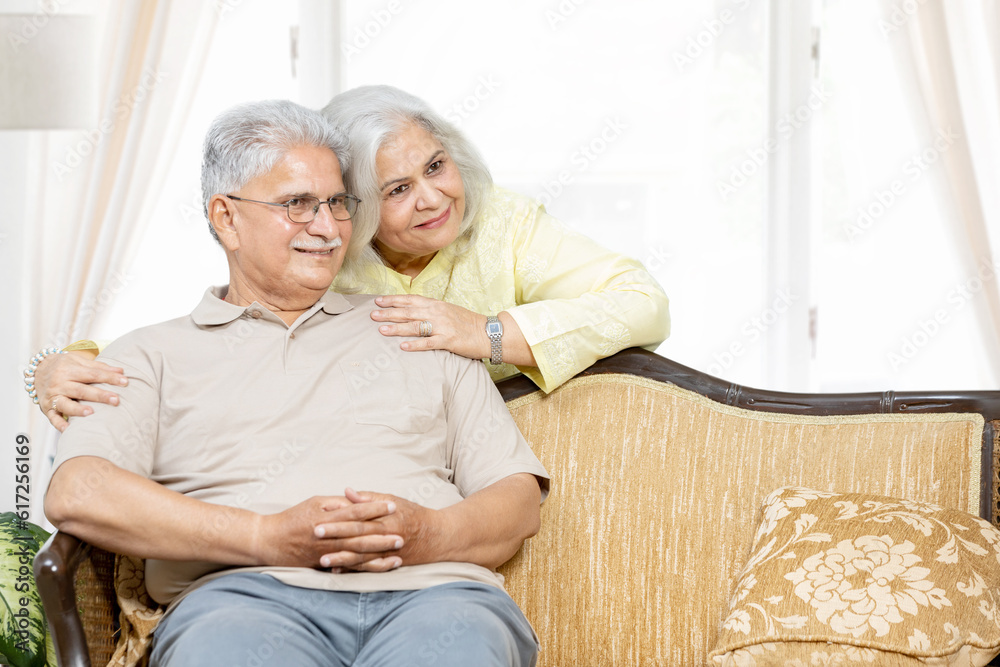 Front view of happy senior diverse couple sitting in room at sofa . Authentic Senior Retired Life Concept Front view of happy senior diverse couple sitting in room at sofa . Authentic Senior Retired Life Concept