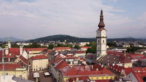 Wallpaper Mural Clock tower of Klagenfurt chapel standing out above red roofs, aerial pullback Torontodigital.ca