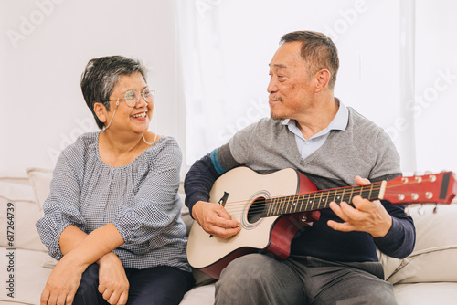 Senior elderly couple lover holiday home activity old man playing guitar music make elder wife happy smile