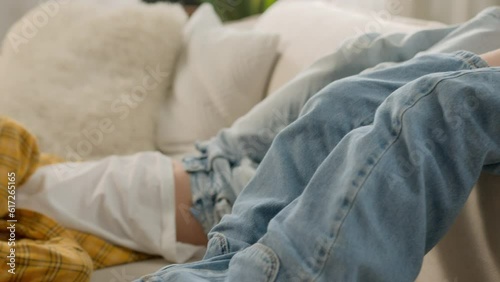 Two little funny carefree playful happy caucasian girls children kids sisters friends lie upside down in living room couch fooling around playing together having fun lying on sofa at home laughing