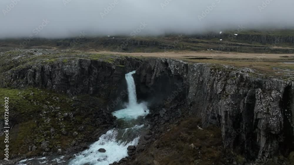 Folaldafoss Waterfall: A close-up aerial shot of the beautiful Icelandic waterfall on a cloudy day. Folaldafoss Waterfall: A close-up aerial shot of the beautiful Icelandic waterfall on a cloudy day.