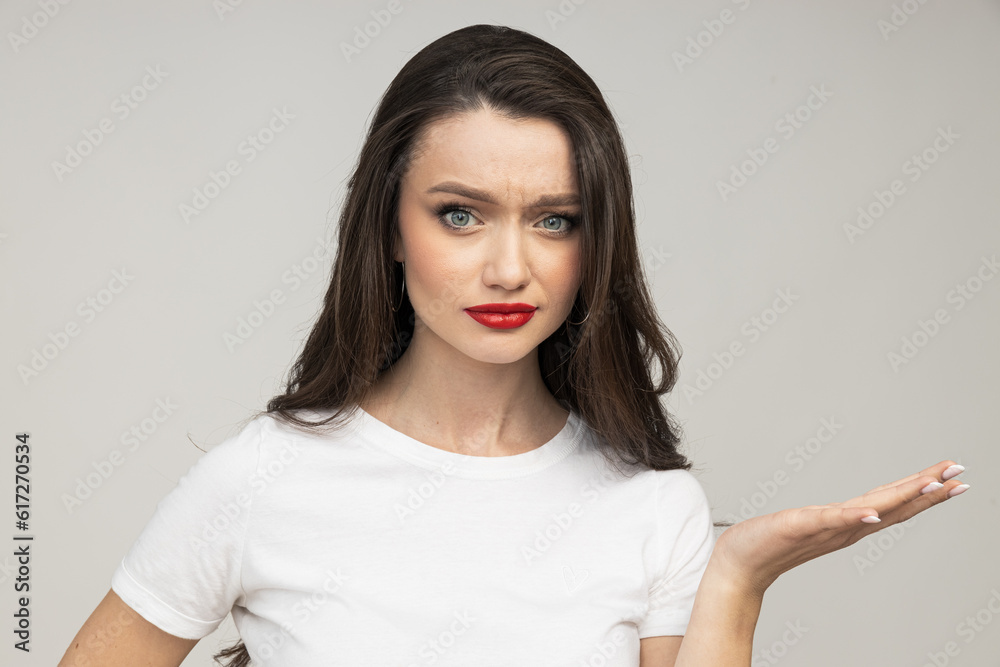 Attractive brunette in a white t-shirt is confused Attractive brunette in a white t-shirt is confused