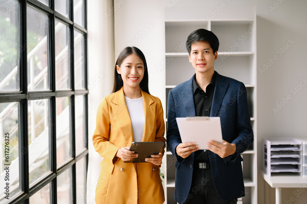Two Asian business woman and man discuss investment project working and planning strategy with tablet laptop computer in office. Two Asian business woman and man discuss investment project working and planning strategy with tablet laptop computer in office.