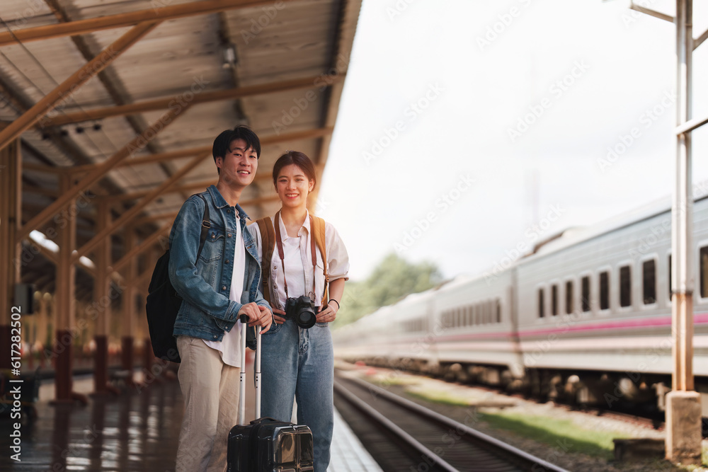 Asian couple at railway station have happy moment. Tourism and travel in the summer
