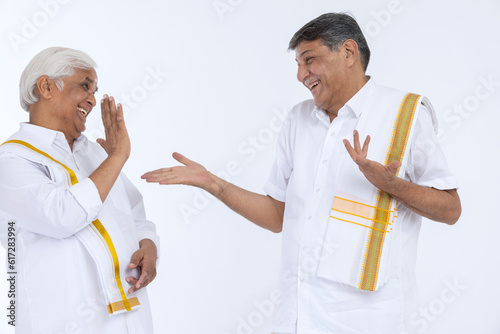 Two south indian happy senior men embracing each other isolated on white background.