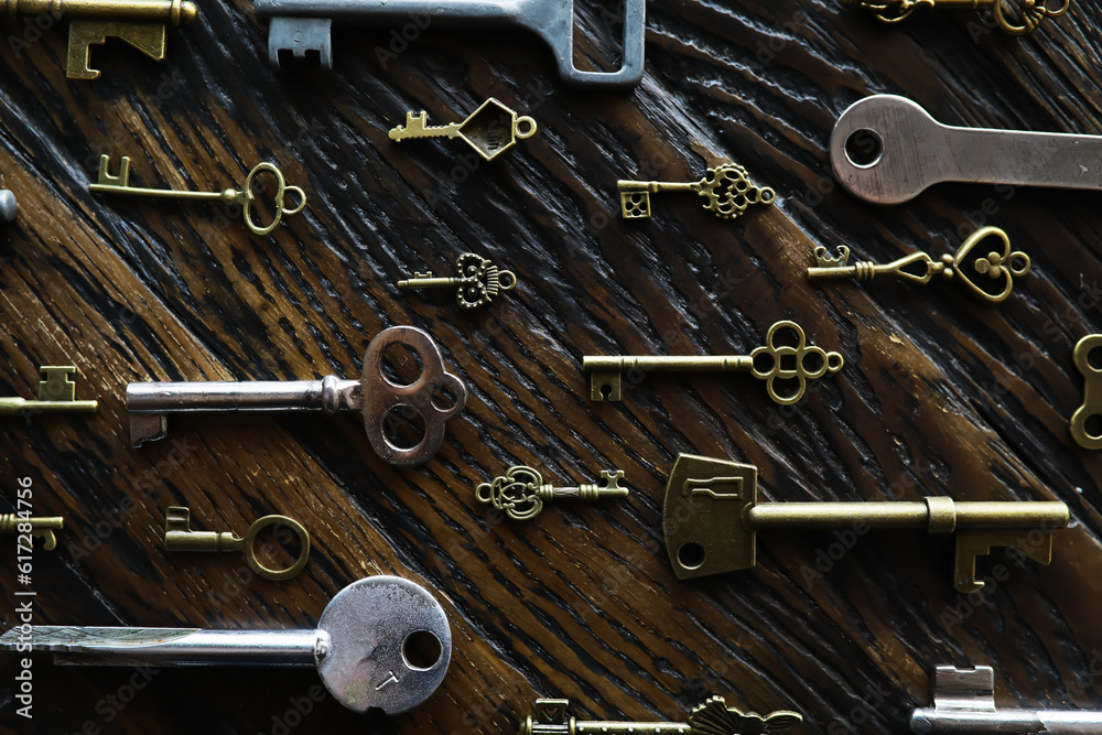A lot of metal keys and a steel lock on a wooden boards. Vintage rusty padlock surrounded by old keys. Security protection concept. Internet hacker or cyber safety A lot of metal keys and a steel lock on a wooden boards. Vintage rusty padlock surrounded by old keys. Security protection concept. Internet hacker or cyber safety