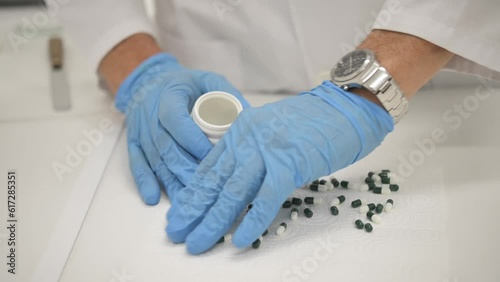 Crop compounding pharmacist putting pills into jar made in lab