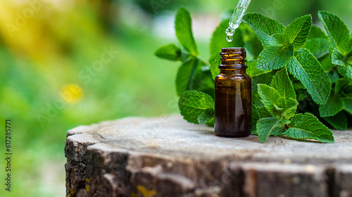 Peppermint essential oil in a bottle. Selective focus. photo