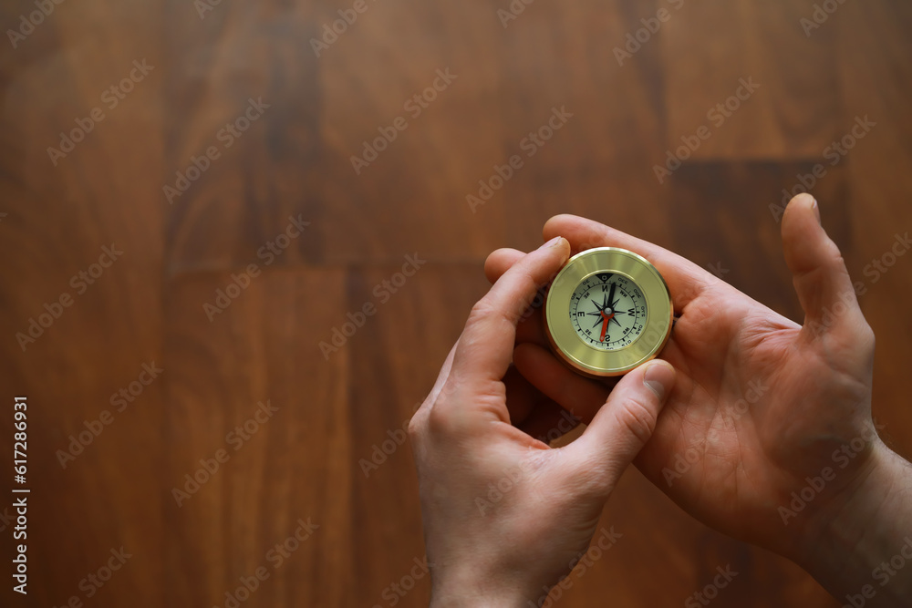 man in suit holding golden compass on gray background man in suit holding golden compass on gray background