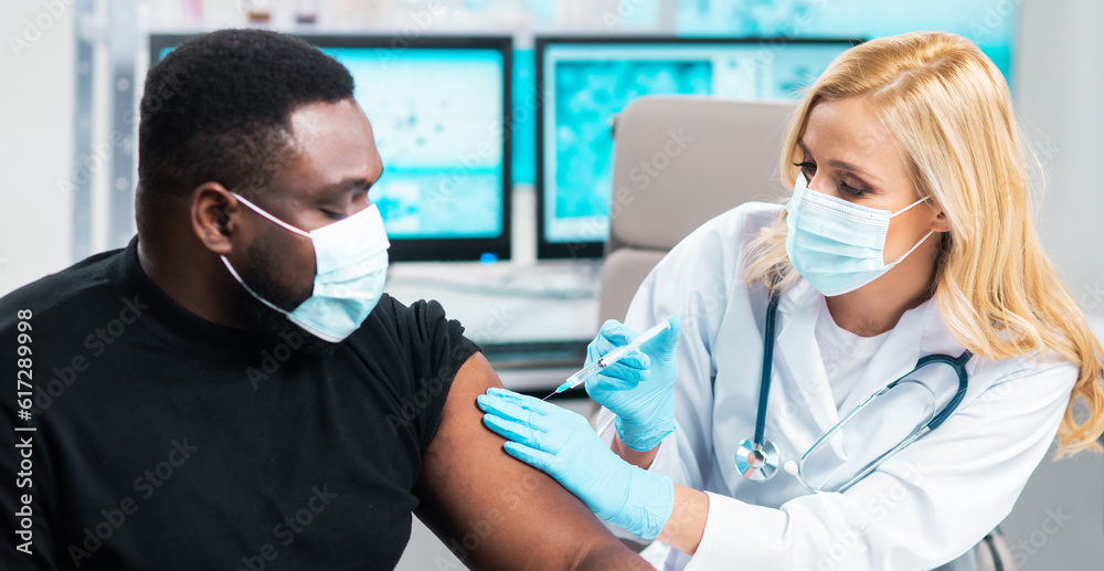 Professional doctor makes a coronavirus vaccine using a syringe and hypodermic needle. Professional medical worker and patient at the hospital office. Vaccination and safety. Professional doctor makes a coronavirus vaccine using a syringe and hypodermic needle. Professional medical worker and patient at the hospital office. Vaccination and safety.