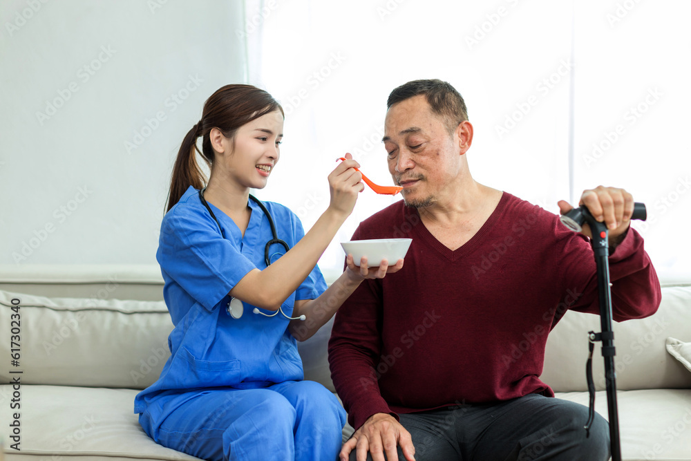 Elderly care feeding an elderly woman at retirement house. Caregiver nurse take care a Senior patient. Nurse helping senior Man feeding food. Physician nurse support to elderly patient in living room Elderly care feeding an elderly woman at retirement house. Caregiver nurse take care a Senior patient. Nurse helping senior Man feeding food. Physician nurse support to elderly patient in living room