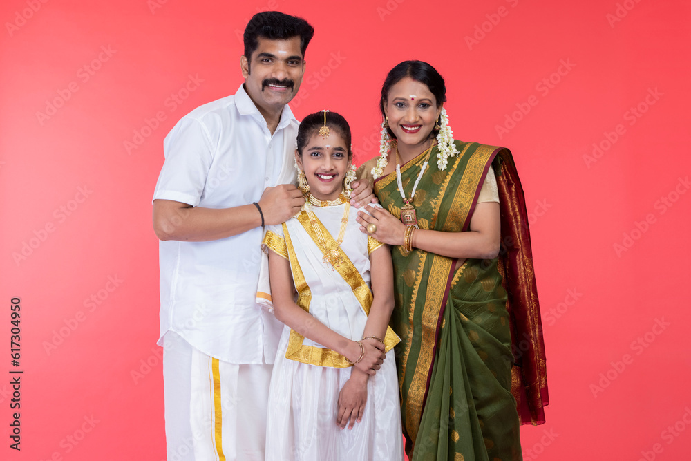 South Indian family posing in traditional clothing South Indian family posing in traditional clothing