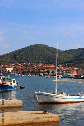 Small fishing boat and picturesque skyline in Vela Luka, island Korcula, Croatia. © jelena990