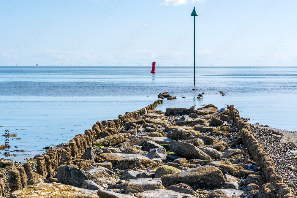 During low tide, these breakwaters become visible along the south side of the island of Vlieland with the windmills in the IJsselmeer along the Breezanddijk in the distance