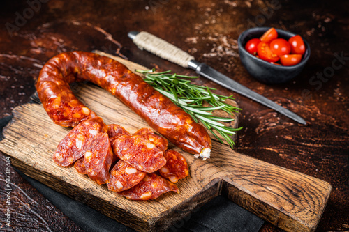 Dry cured Spanish Chorizo sausage, slices of meat with herbs and spices. Dark background. Top view