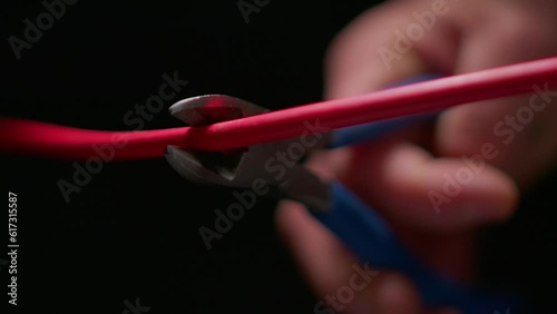 Bomb Disposal Technician Cuts a Copper Cable With Wire Cutters in Extreme Macro. Slow-motion macro shot of wire cutters slicing through a copper cable, suggestive of bomb disposal or disarmament.