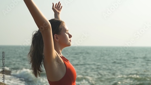 фотографія young woman has raised her hands to the sky and is inhaling the scent of the oce